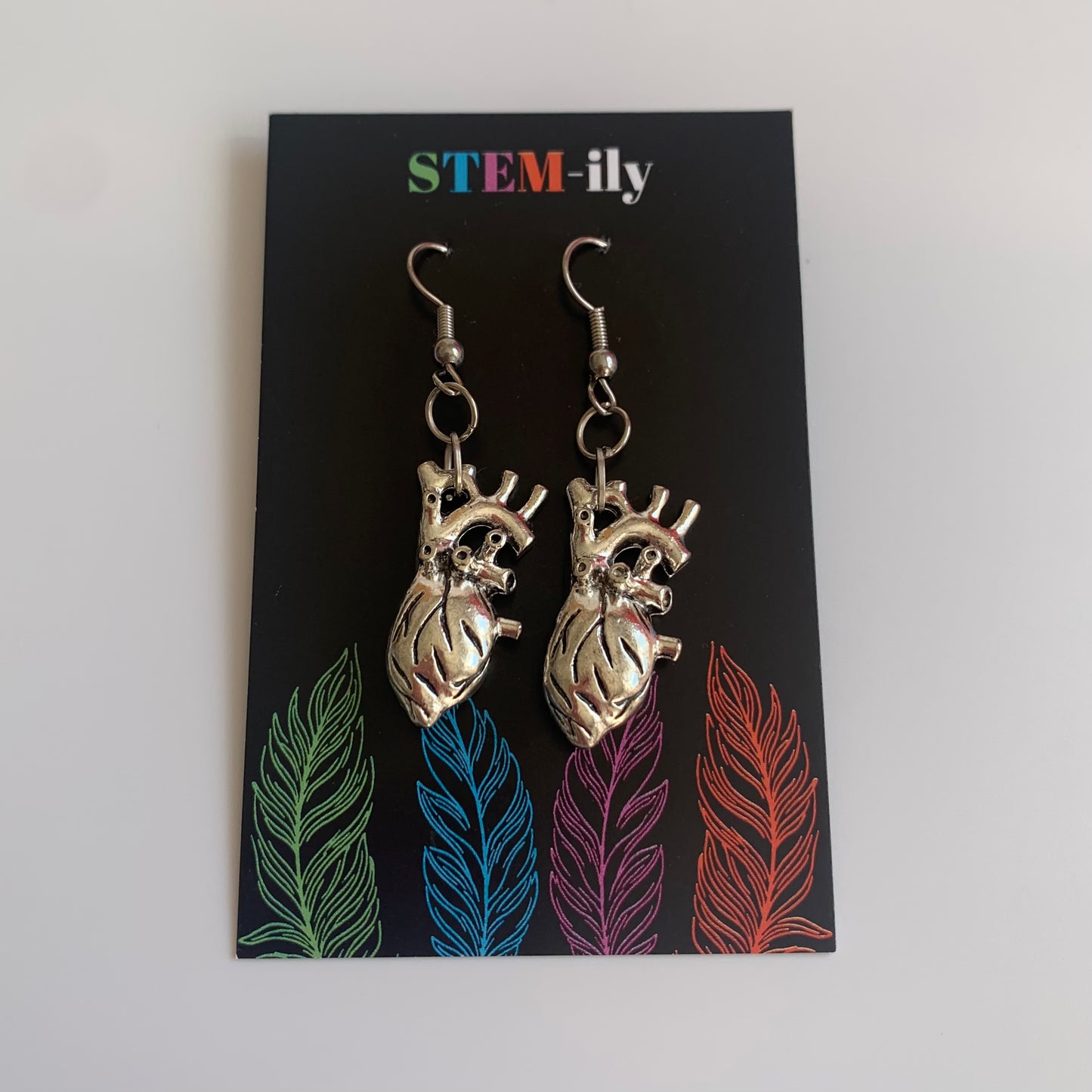 Silver anatomical heart dangle earrings